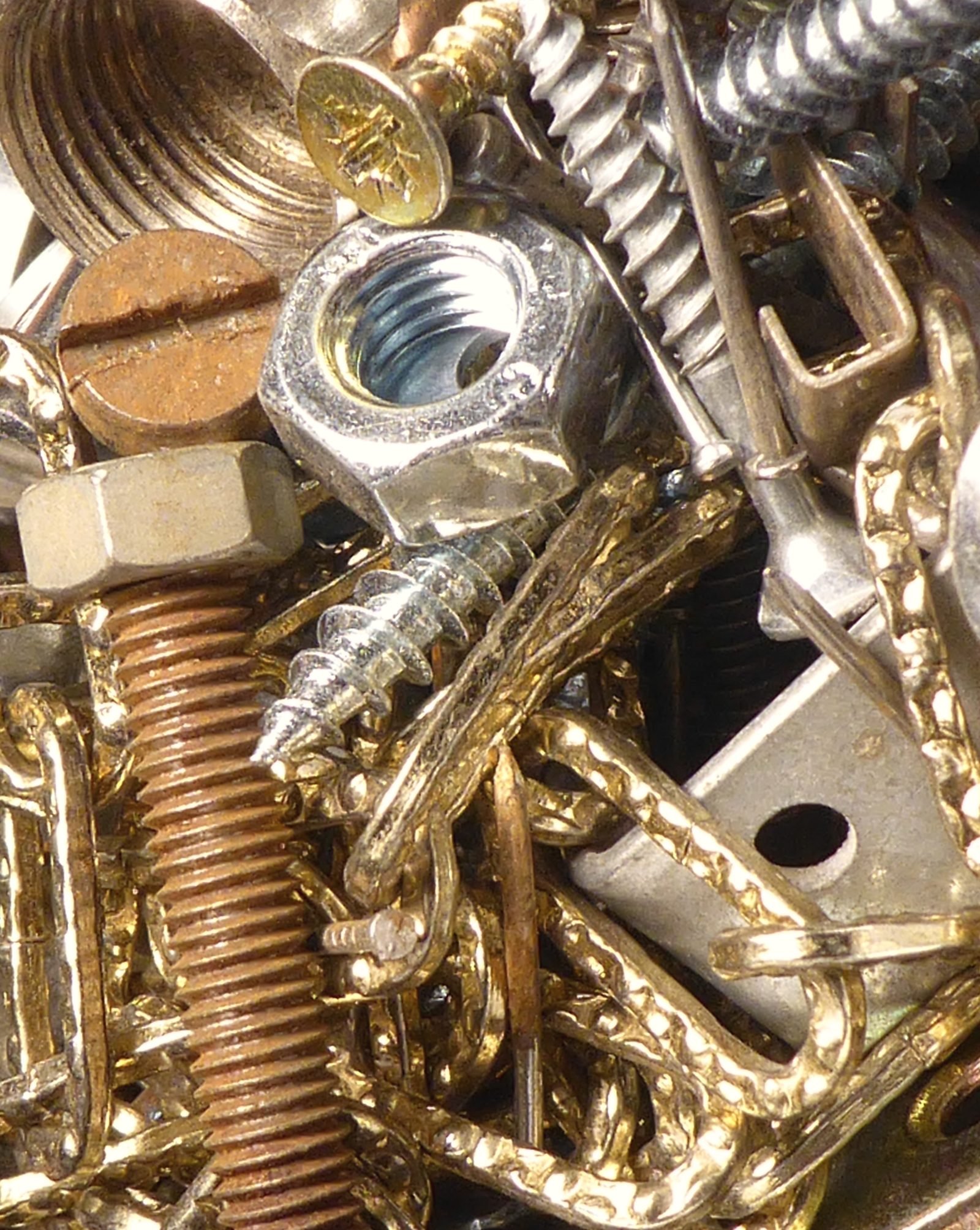 Brass and zinc screws, nuts and chain in a heap